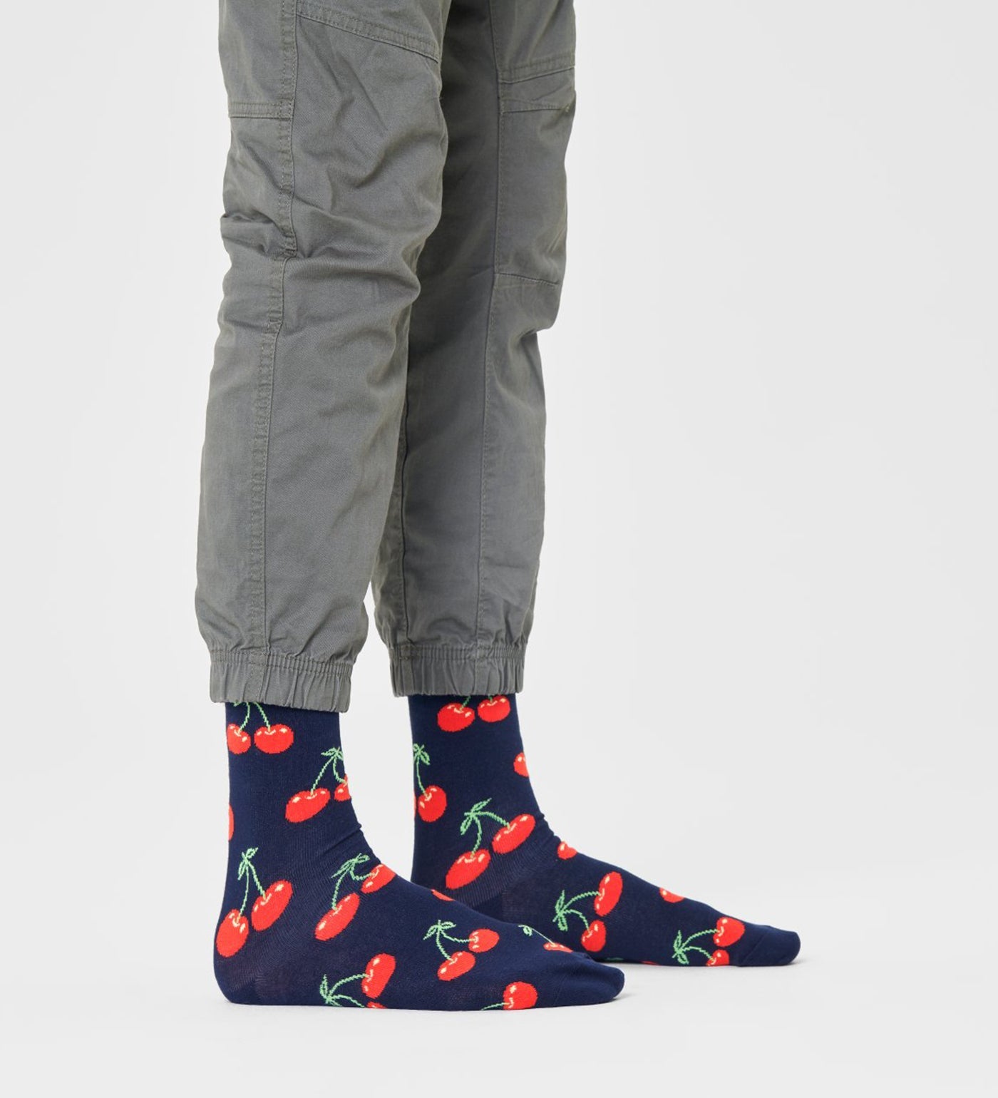 Bright red cherry design on unisex crew-length socks suitable for women and men, stylish and comfortable for everyday wear.