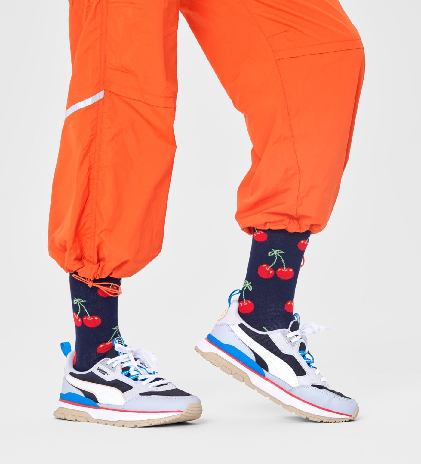 Bright red cherry design on unisex crew-length socks suitable for women and men, stylish and comfortable for everyday wear.